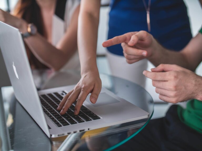 hands pointing and typing on a laptop